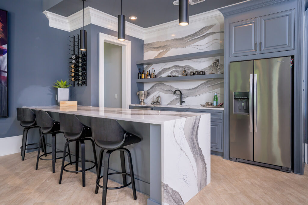 blue basement bar with white and black quartz waterfall island