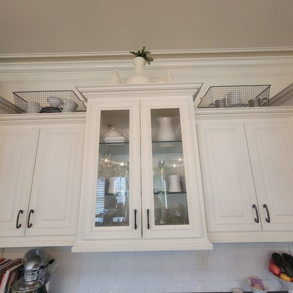 close up shot of off white cabinetry with glass-cabinet doors in the middle