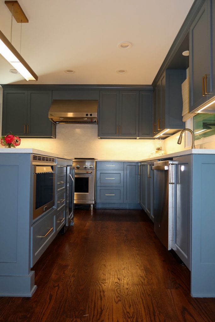 photo centered between deep blue kitchen cabinets and deep blue kitchen island
