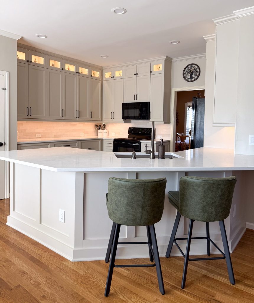 vertical shot of bright white kitchen with white countertops, cabinets and in-cabinet and under-cabinet lighting