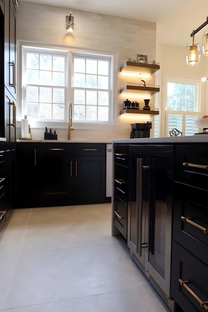 modern kitchen with black cabinetry, gold fixtures and lit floating shelf