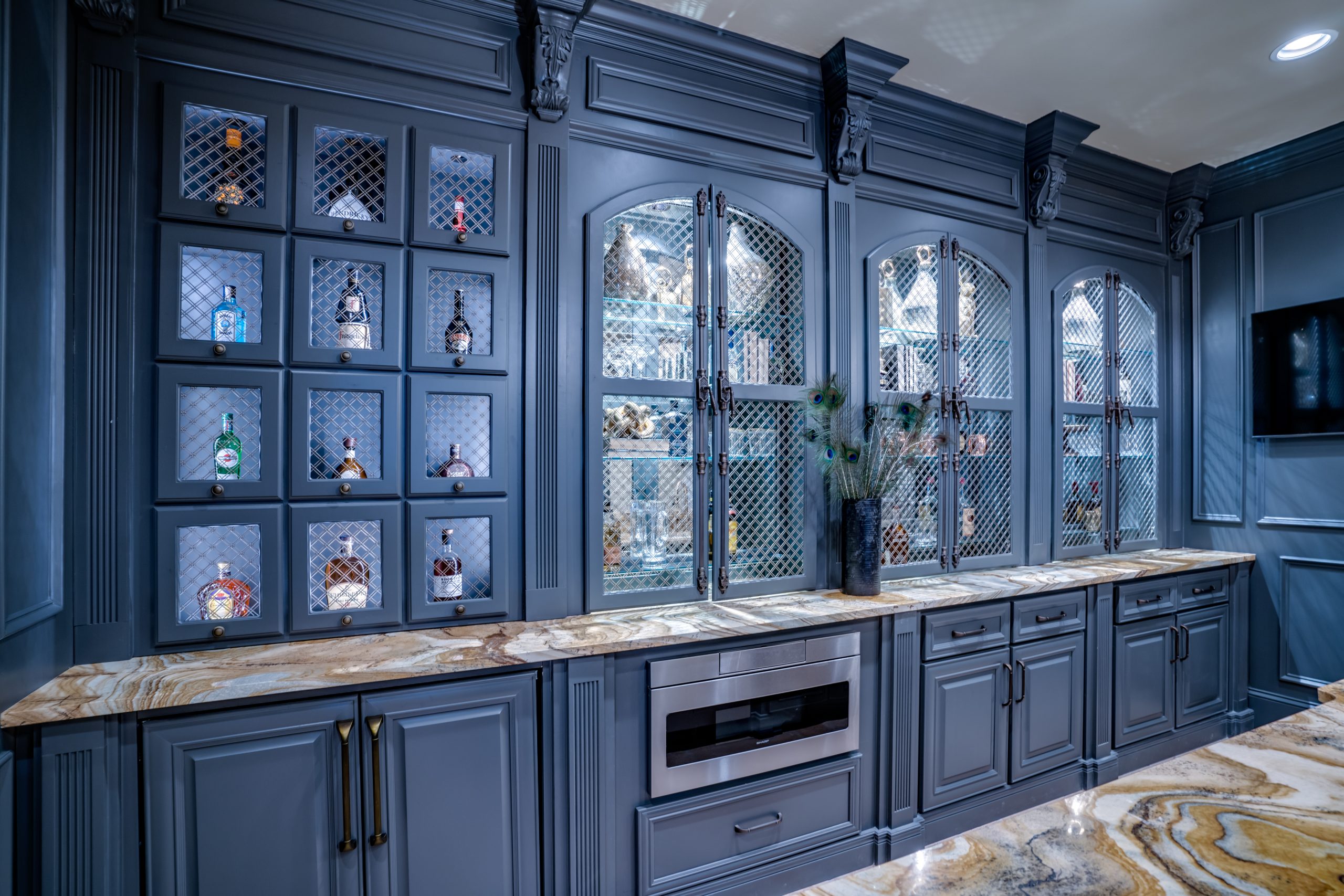 basement bar with blue cabinetry and glass doors