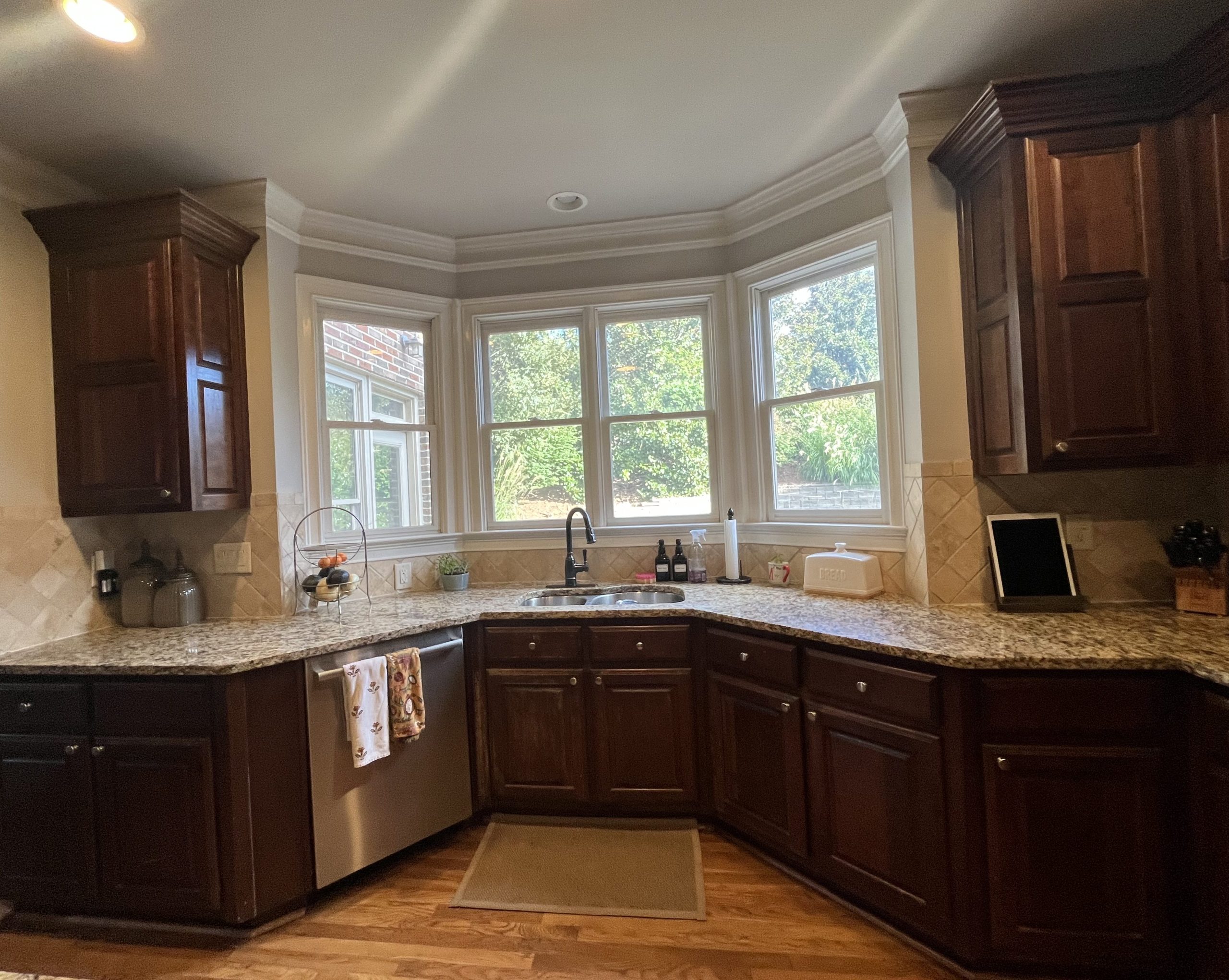 before image of traditional kitchen with brown wooden cabinets and granite countertop