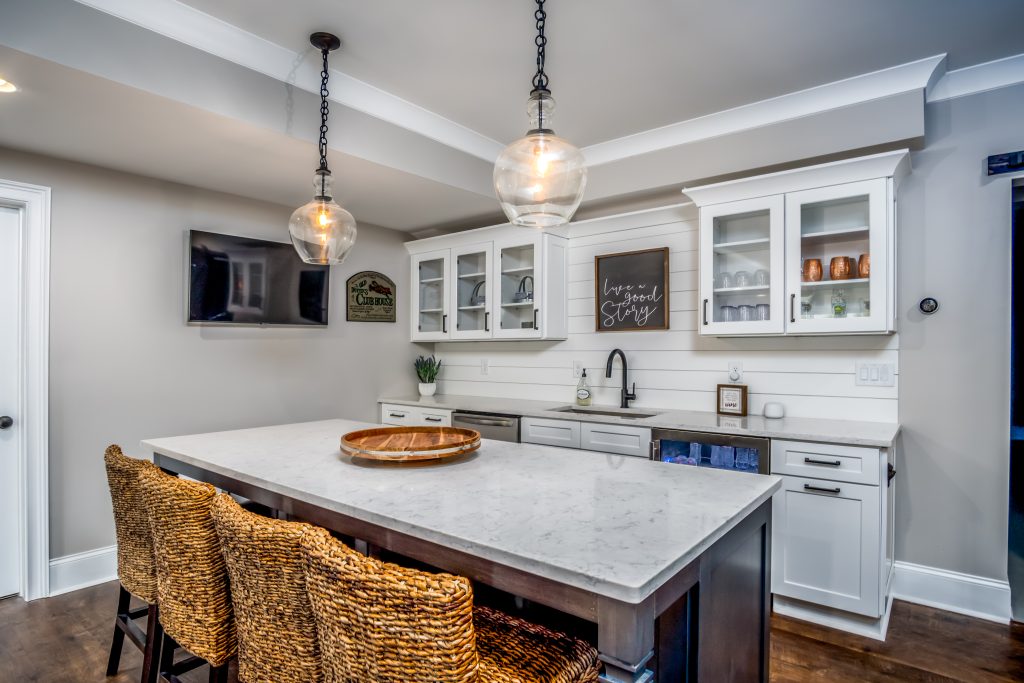 Kitchenette in basement with white cabinetry