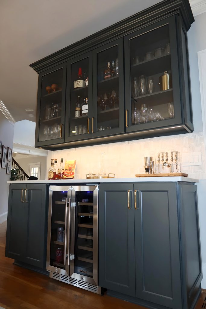 blue wet bar with white countertops and glass cabinet doorsq