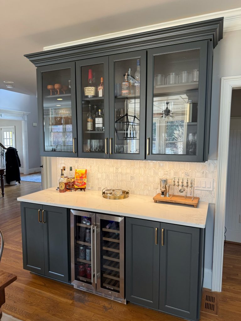 blue wet bar with white countertops and glass cabinet doorsq