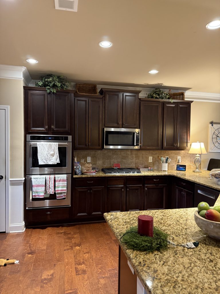 Traditional kitchen with dark wood cabinets and granite countertops before renovation
