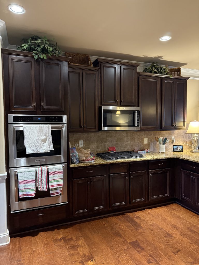 Traditional kitchen with dark wood cabinets and granite countertops before renovation