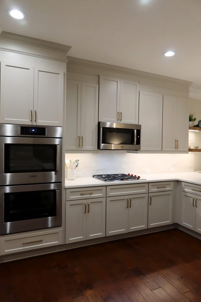Modern kitchen with light neutral cabinetry, quartz countertops, and built-in stainless steel appliances