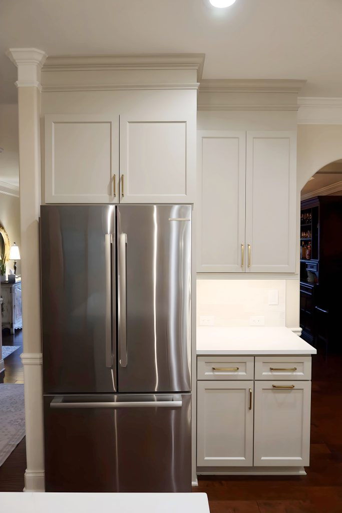 Modern kitchen with light neutral cabinetry, quartz countertops, and built-in stainless steel appliances