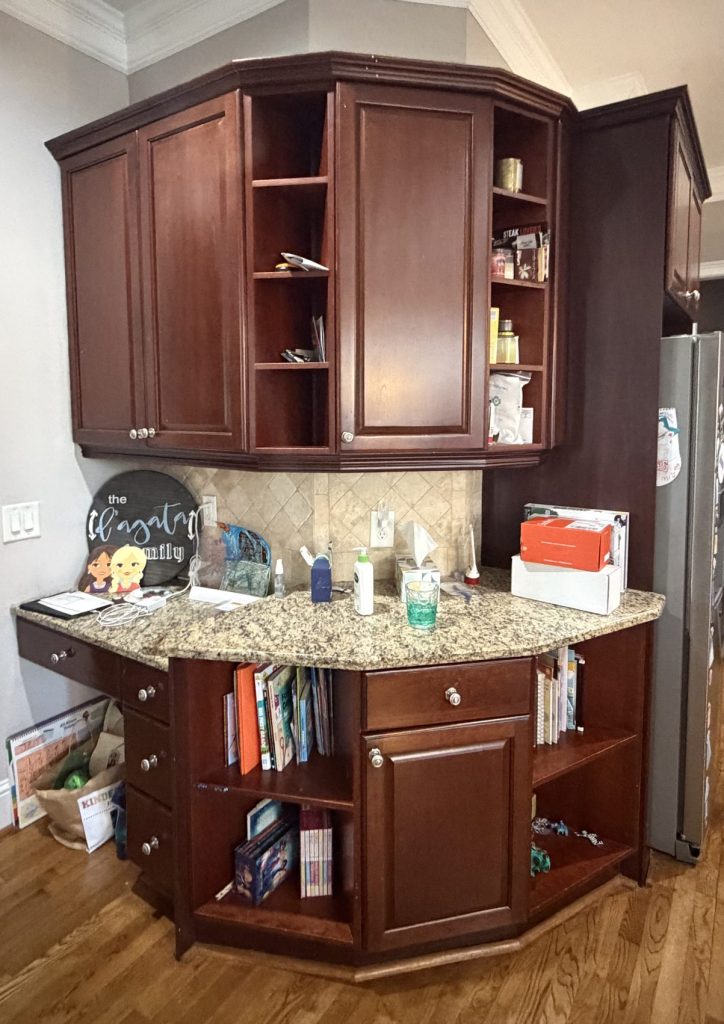 Kitchen before renovation with dark brown cabinets, granite countertops, and tile backsplash.