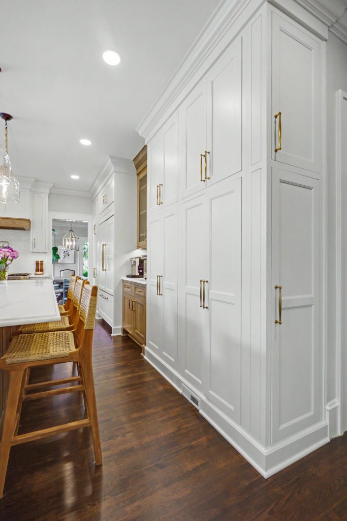 Floor-to-ceiling white inset cabinetry with integrated Sub-Zero refrigerator