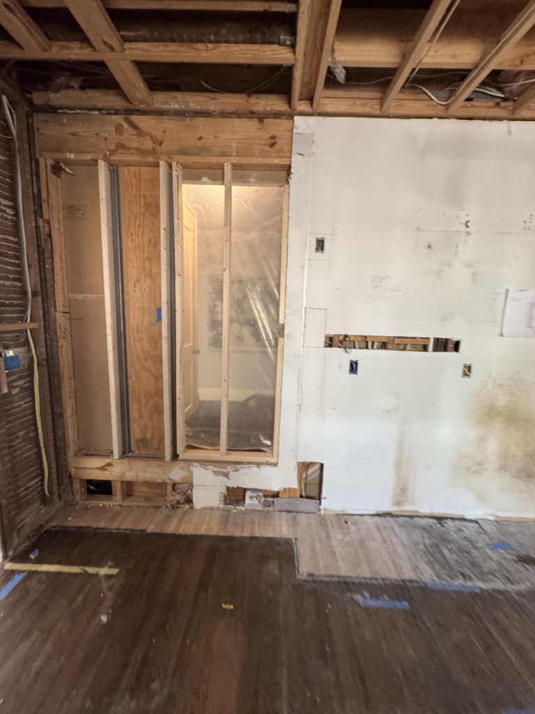Bare kitchen interior with exposed framing before renovation