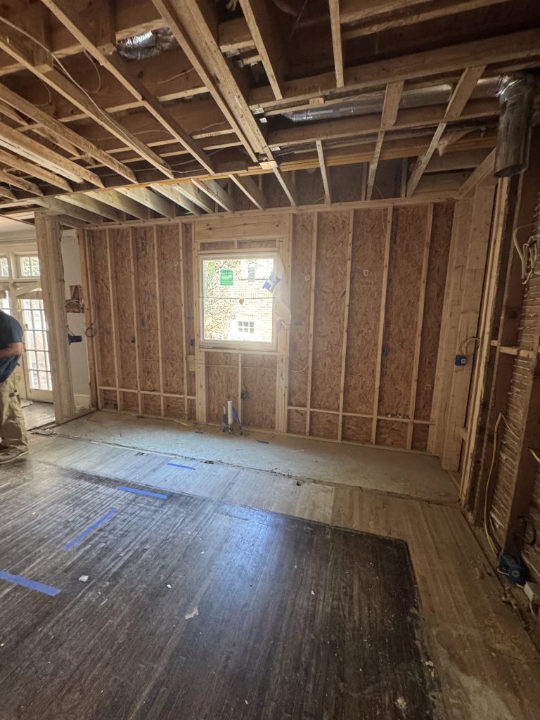 Bare kitchen interior with exposed framing before renovation