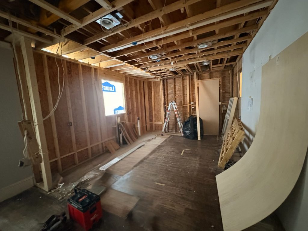Bare kitchen interior with exposed framing before renovation
